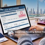 Traveller checking a pending Dubai visa application on a laptop with a passport and travel documents nearby.