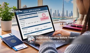 Traveller checking a pending Dubai visa application on a laptop with a passport and travel documents nearby.